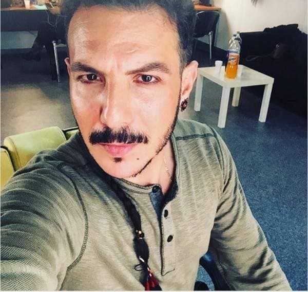 باسل خياط بقرط في الأذن و ضفيرة